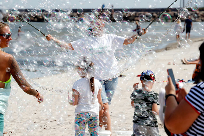 7月10日在拉脱维亚罗哈的波罗的海海滩，人们在阳光下完起泡泡。（欧新社）