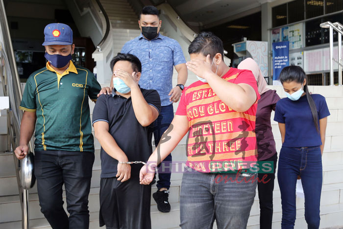 2名男被告（用手遮脸者）及女被告（后右），被警员带上芙蓉法庭面对控状。