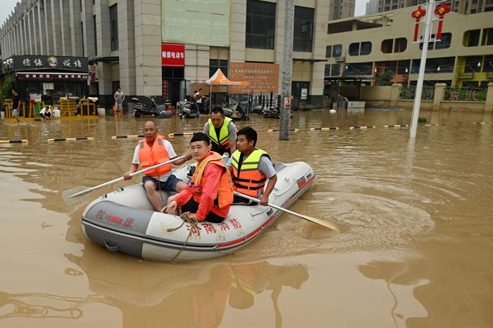 郑州市遭遇严重洪灾，民众乘船撤离灾区。（法新社）