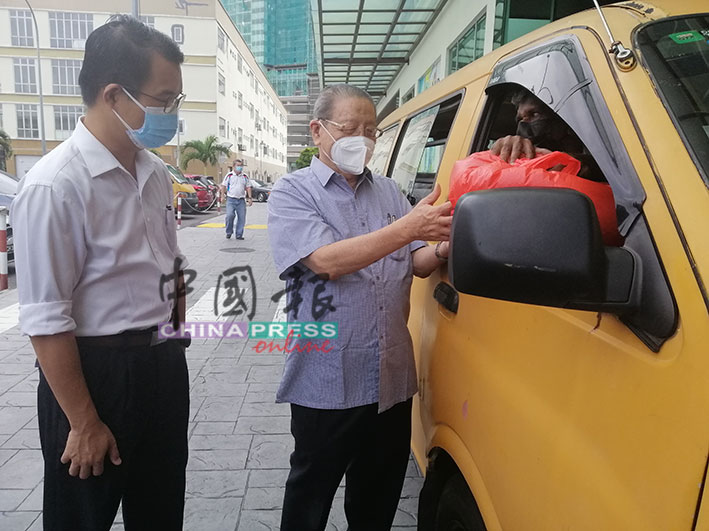 陈泓宾（左起）与林吉祥派送物资给80名学生巴士司机。