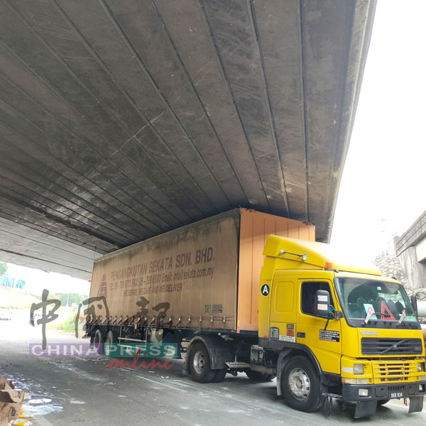 多辆大型货卡车顶几乎被卡住，庄雪和将向工程局反映天桥限高问题。