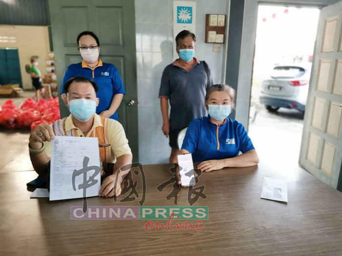郑顺和（坐者左）展示警方报案书，控诉疫苗中心违反接种标准作业程序；坐者左为洪瑞樱，站者左起李丽珺与黄协来。