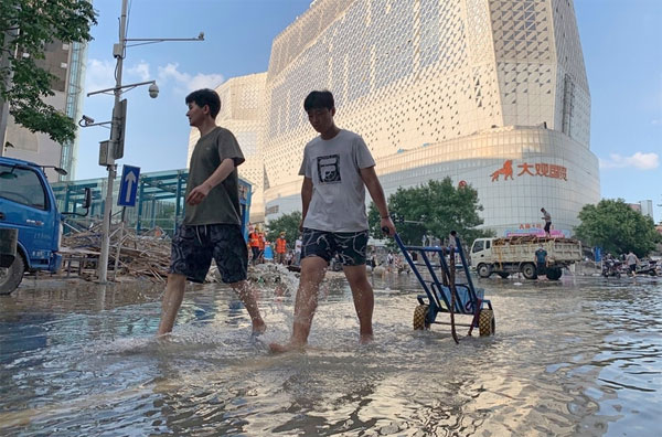 郑州才刚经历水患，图为7月24日居民涉水而过。