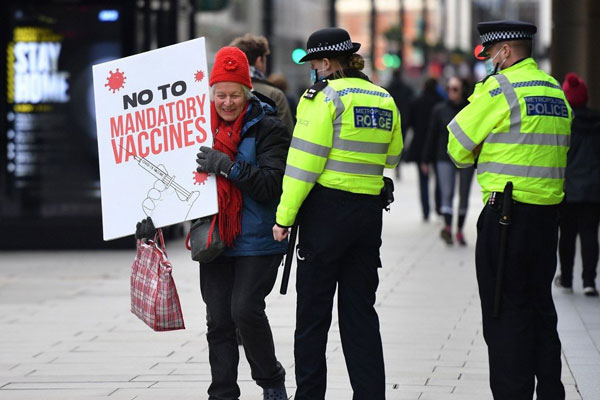 去年11月，伦敦有妇女举牌反对强制接种疫苗。