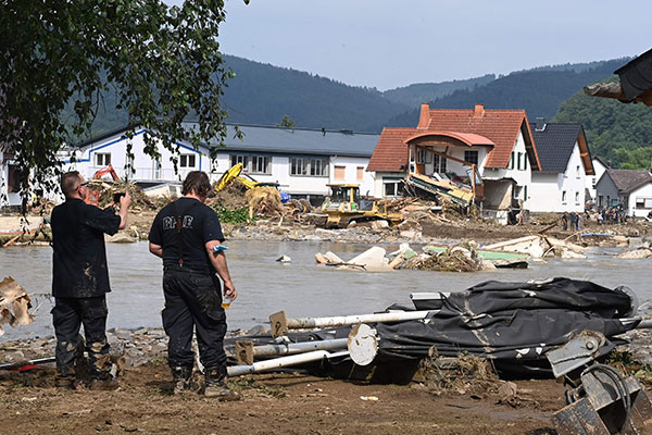 一名工人周六在德国西部巴特诺因阿尔-阿尔韦勒附近的因苏尔拍摄被洪水捣毁的区域。（法新社）
