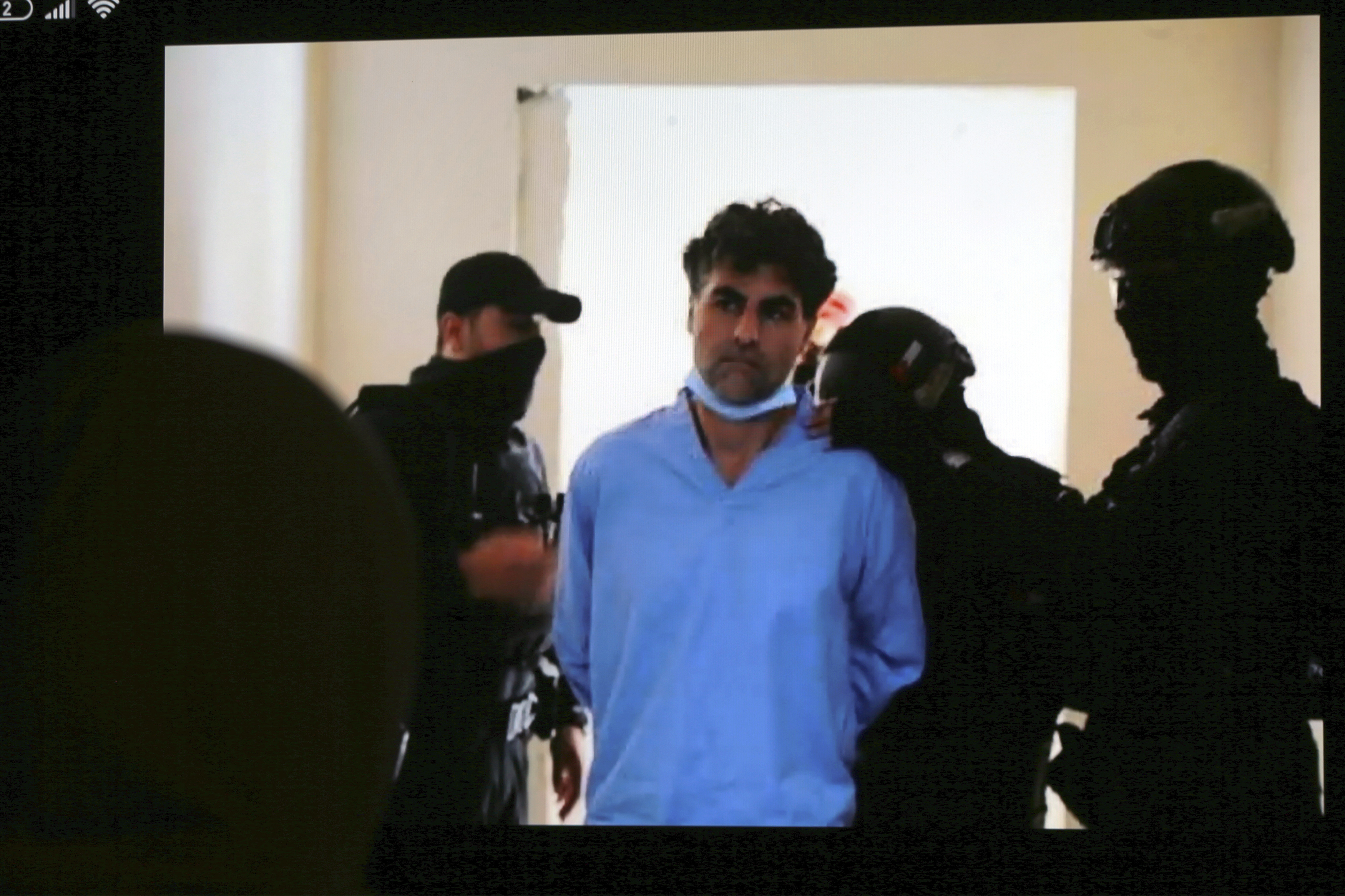 前沙地阿拉伯特使哈山（中），被警察押往法庭受审。（美联社）