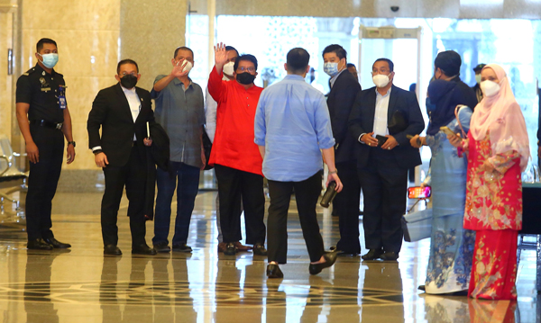 东姑安南（左4）离开法庭前，向媒体打招呼。