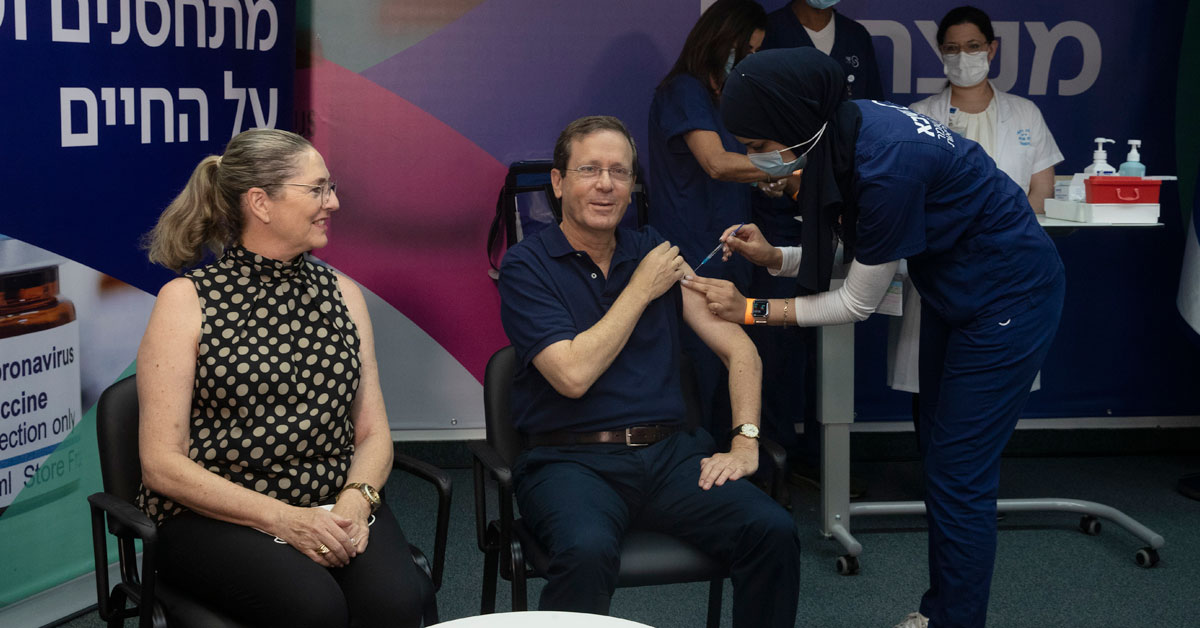 以色列总统赫佐格（中）30日在夫人迈克尔（左）的陪同下，接种第3剂辉瑞疫苗。（美联社）
