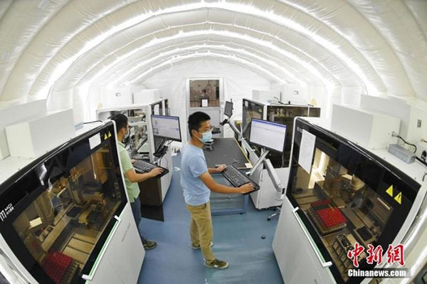 7月26日，南京“火眼”实验室正在南京国际博览中心加紧搭建，工作人员调试设备。（中新网）