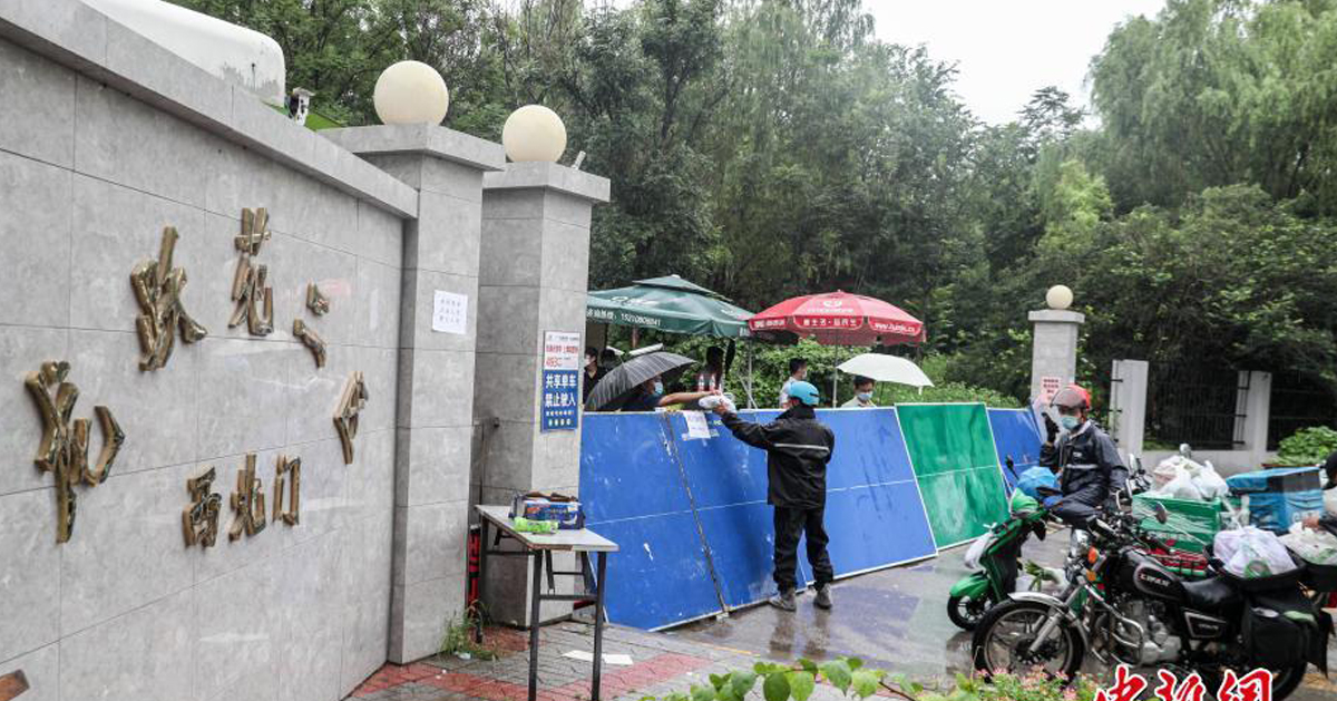 北京新增确诊病例所在的居民小区周四封闭，外卖人员向小区内递送居民购买的生活用品。（中新网）