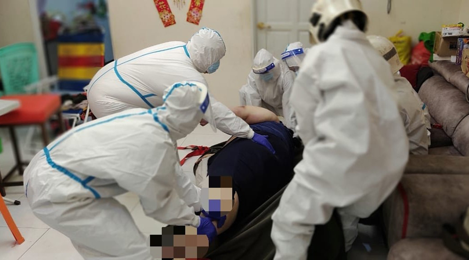 6名消拯员穿上个人防疫设备，把遗体移上担架。