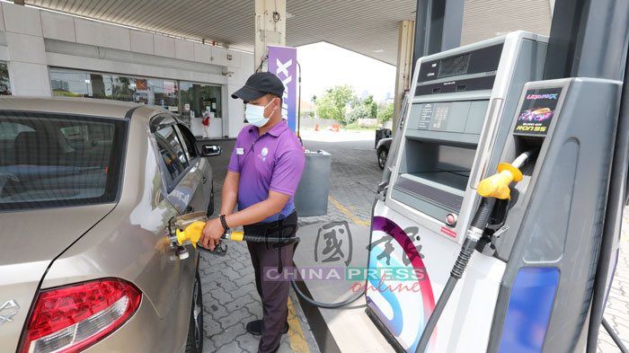 隆市泗岩沫FIVE油站的员工为顾客添油，以便减少接触，保障双方安全。