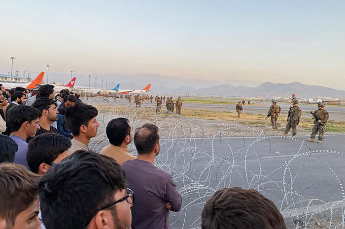 阿富汗人民（左）涌往喀布尔机场，美国士兵在场驻守。（法新社）