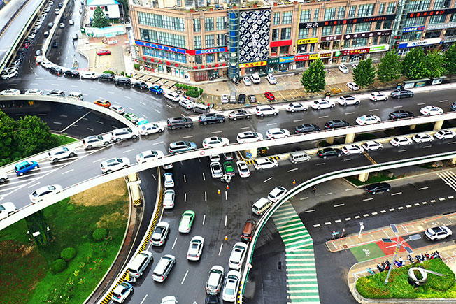 为应对新一轮强降雨，市民周日将车辆临时停放在郑州市河医立交桥上。（美联社）
