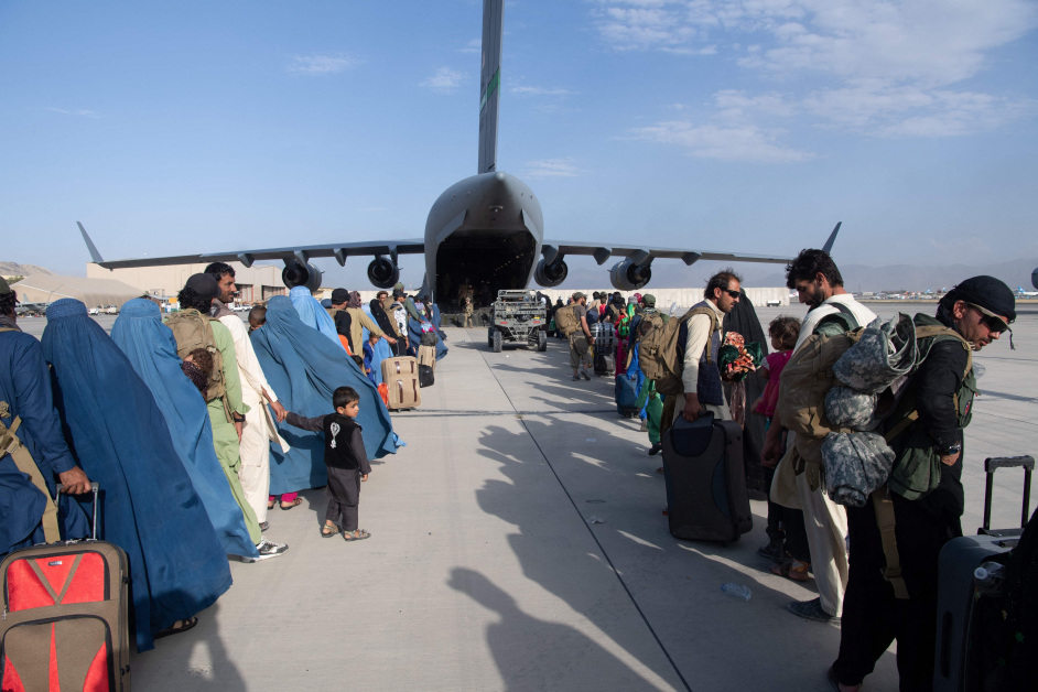 24日排队登机、准备离开喀布尔机场的人们。（法新社）