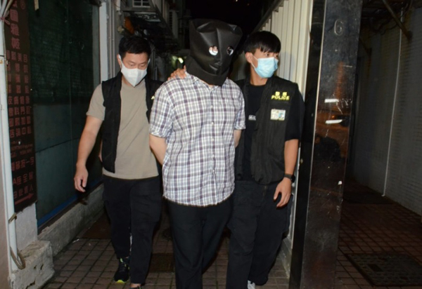 涉案男子戴上黑色头套，遭警方逮捕。