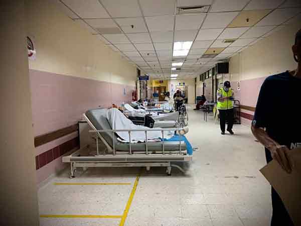 在非新冠肺炎病房的走廊，可见摆满病床。