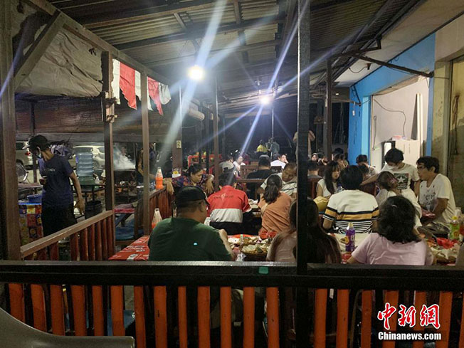 周三在峇厘岛著名旅游景点金巴兰海滩海鲜餐馆，一些游客正在用餐。（中新网）