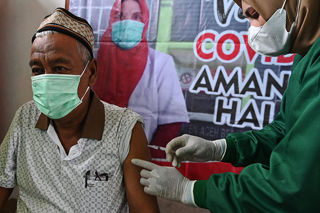 亚齐省班达亚齐市外郊加洛特村一名老人周四接种中国科兴疫苗。（法新社）