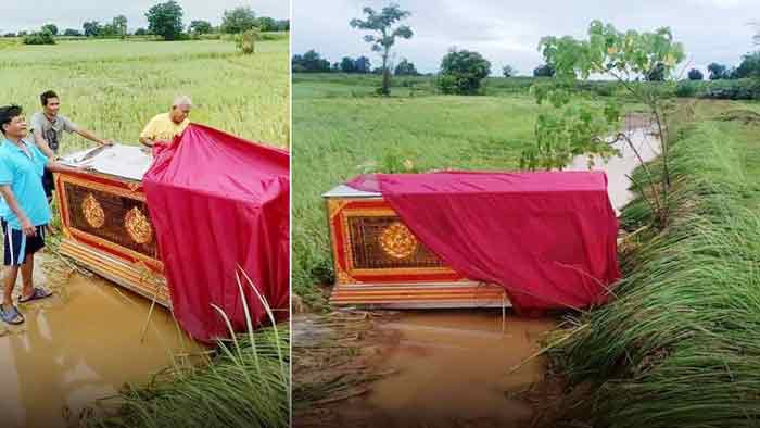 佛寺的红色空棺材，竟然被洪水冲到农田里（右图）。佛寺工作人员准备把棺材搬回佛寺。