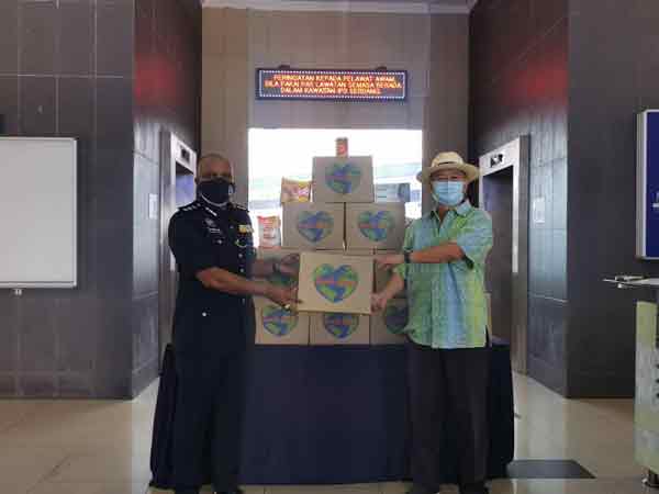 李金友（右）移交食物包给沙登警区代表。