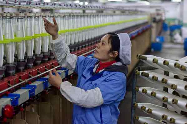 中国对高耗能产业展开全国大限电。图为浙江纺织厂的工人在生产线工作。
（档案照）