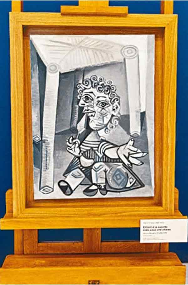 图为毕卡索1938年完成的《坐在椅子下拿棒棒糖的小孩》