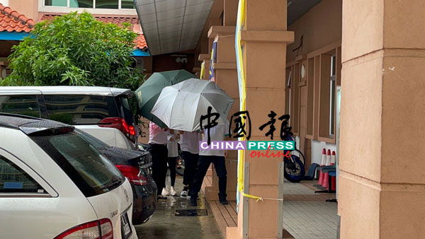 尤瑞庆的妻儿在太平间，全程用雨伞遮挡，躲避媒体镜头。