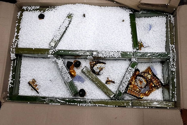 调查人员开验货箱发现22块海洛因砖堆叠成隔板，内摆放24尊佛像，共查获8.14公斤海洛因。（中央社）