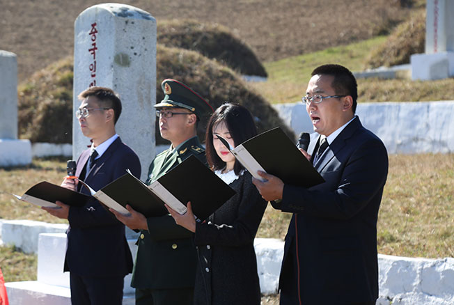 在朝鲜长津湖畔的中国人民志愿军烈士合葬墓地，中国驻朝鲜大使馆外交官代表朗诵献给长眠于此的志愿军英烈的祭文。(新华社)
