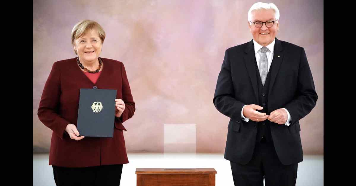 默克尔（左）从总统斯泰因迈尔手中接下正式解雇证书，结束其领导德国近16年的任期。（欧新社）