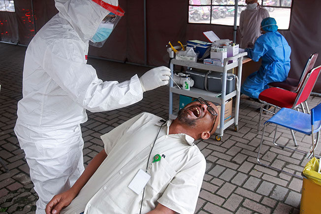 棉兰一名男子周四接受新冠病毒检测时。（美联社）