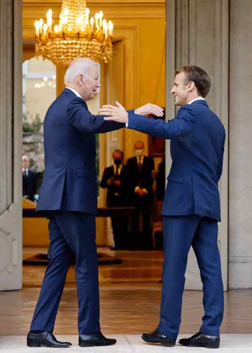 美国总统拜登（左）与法国总统马克龙29日在法国驻罗马教廷大使馆会晤时，双方伸手拍肩。（法新社）