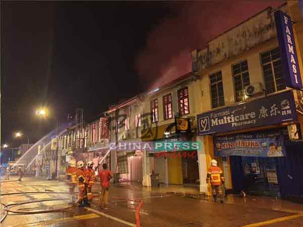大火蔓延至加叻大街的店铺，消拯员在喷水灭火。（徐国庭摄）