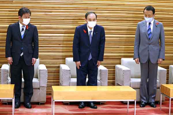 日本首相菅义伟（中）、外长茂木敏充（左）和财长麻生 太郎，周一出席临时内阁会议。（法新社）