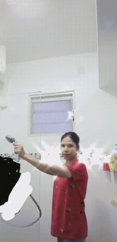 视频中可见，女佣拿着花洒为光着身体的老雇主淋浴。（取自网络视频）
