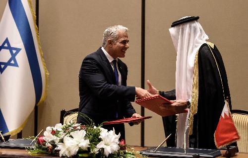 巴林外长札亚尼（右）与以色列外长拉皮德签署协议后握手。（法新社）