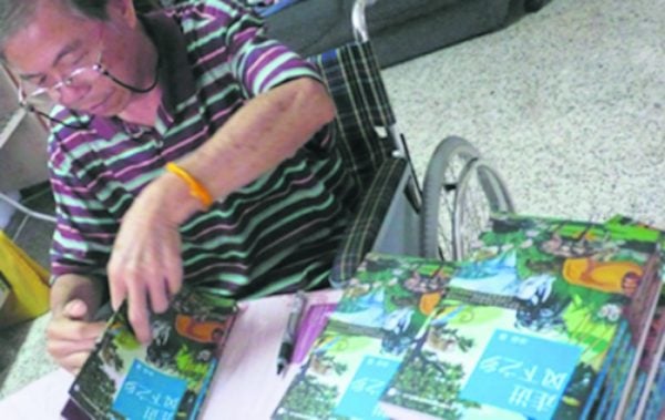 《走进风下之乡》再版时，冰谷中风坐在轮椅上签书。