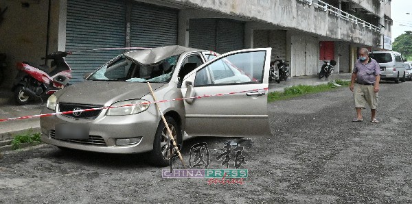 薛金兴（右）无奈看着轿车，在坠楼事件中被砸毁。