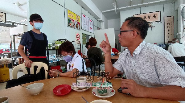 刘志俍（右）询问选民对州选的看法，并鼓励选民踊跃投票。