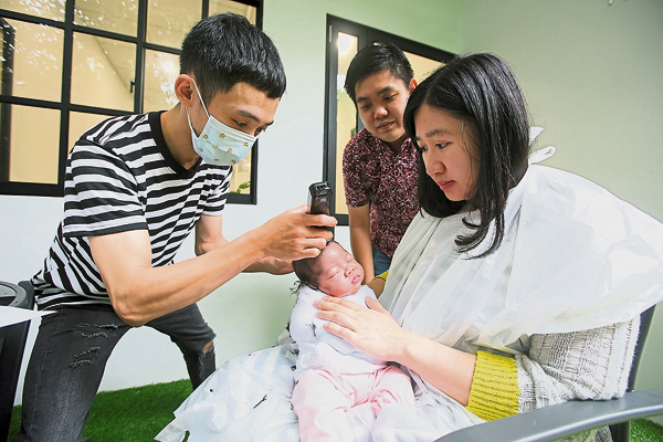 宝宝满月当天，坐月中心将会安排专业的理发师帮宝宝剃头，赵婉如（右起）及毛伟仁不断安慰宝宝，深怕惊吓到宝宝的情绪。