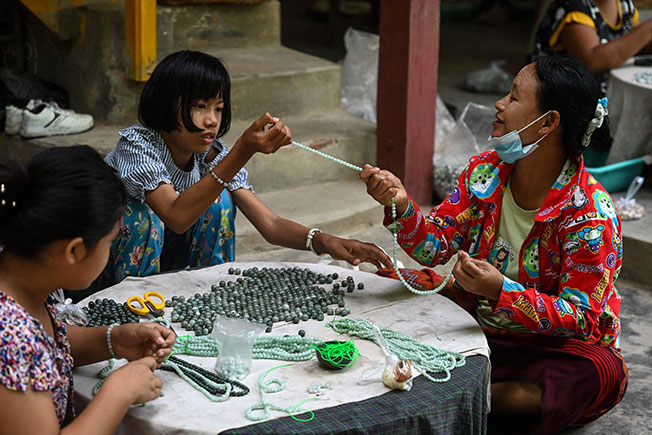 在缅甸玉石交易中心曼德勒西南16公里外的实皆市，玉器家庭作坊里的工人有老有少。（法新社）