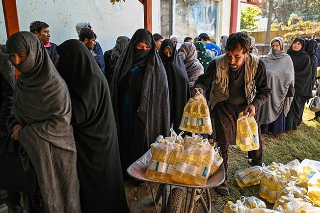 世界粮食计划署上周六在喀布尔派发食物，民众在排队。（法新社）