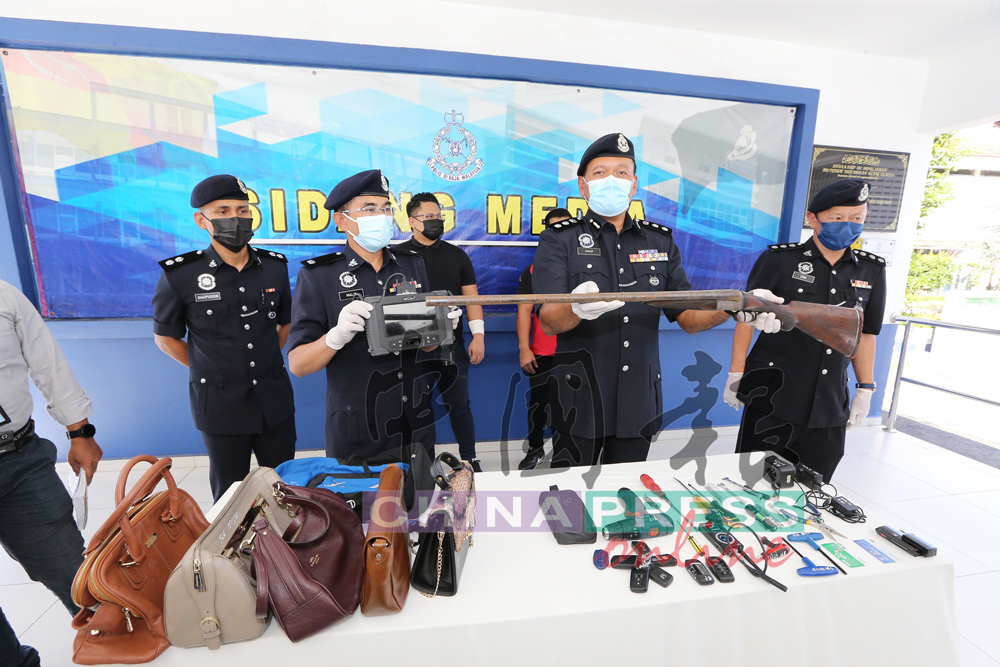 三苏阿马（前排中）展示警方起获的贼赃、干案工具和窃走的双管猎枪。