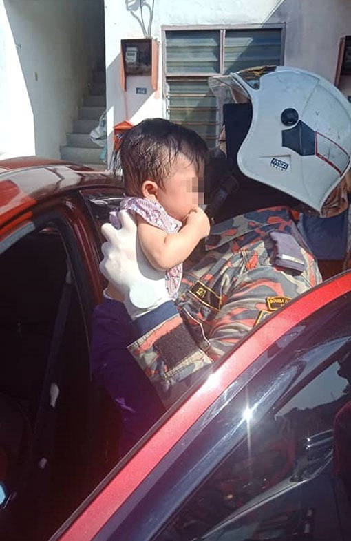 女消拯员把女婴抱出车外。（照片由消拯局提供）