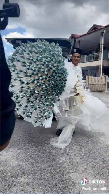 “Seh_Amirul”从车后捧出2万令吉的纸钞花，准备作为引娶新娘的条件。