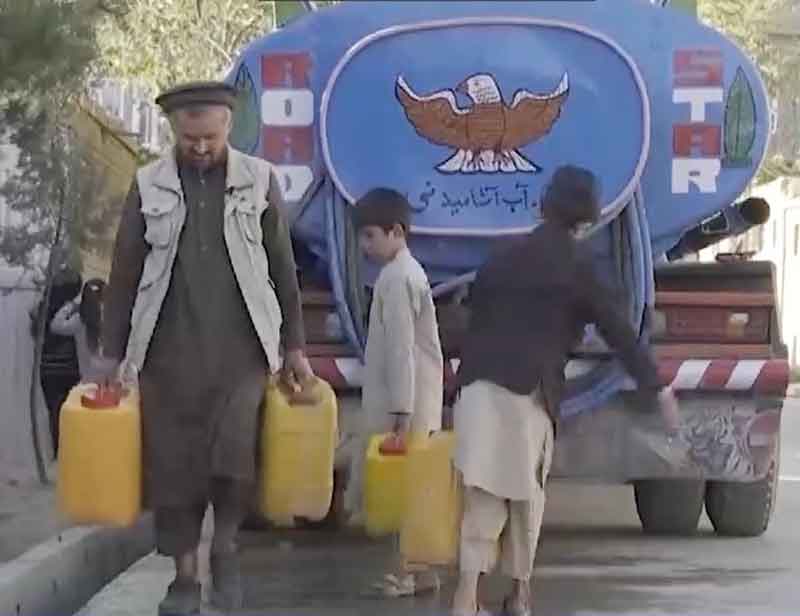 喀布尔居民向水车买水。