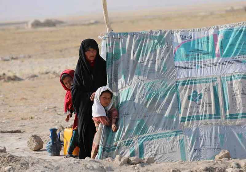 流离失所的阿富汗妇女，只能和孩子生活在简陋拼布帐篷底下。