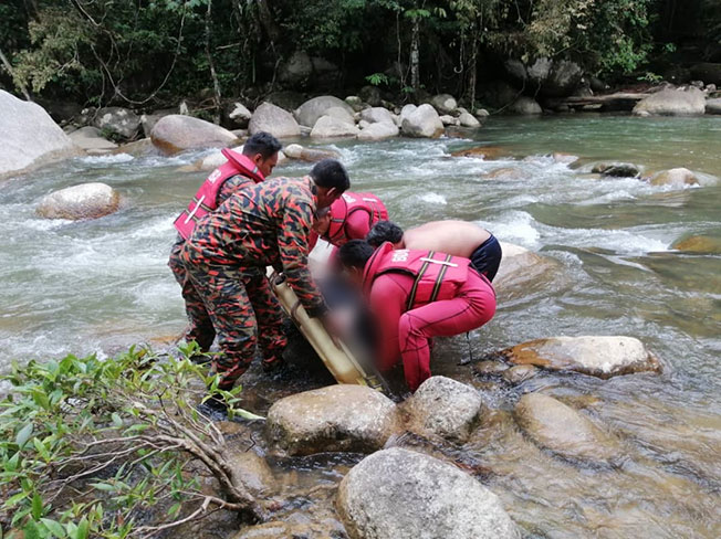 消拯员利用担架把死者遗体从河内打捞上岸。
