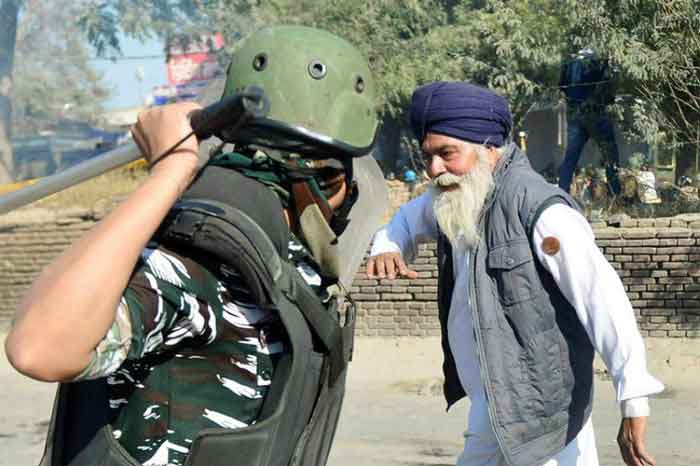 去年12月，警方阻止农民前往德里时，挥棍准备殴打一名锡克族老人。这张照片，也成为当地农民抗争的经典照片。